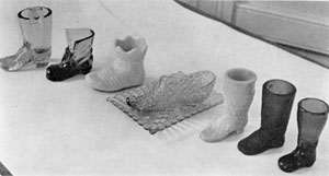 Illustration VII: An Assortment of Boots, Shoes and a Slipper: These were largely of mid-western make. The Daisy and Button slipper affixed to the tray was originally made by the Bryce Brothers Company of Pittsburgh. Illustration VII: An Assortment of Boots, Shoes and a Slipper: These were largely of mid-western make. The Daisy and Button slipper affixed to the tray was originally made by the Bryce Brothers Company of Pittsburgh.