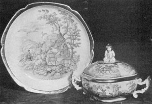 Illustration VII: By Jacob Helchis, Circa 1747: A plate and cover dish decorated with a formalized landscape, deer and hunters. Note the finial in the form of a Chinese man. Illustration VII: By Jacob Helchis, Circa 1747: A plate and cover dish decorated with a formalized landscape, deer and hunters. Note the finial in the form of a Chinese man.