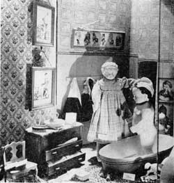 Just Before the Christmas Party: Here Beulah is giving Peter a proper scrubbing. The pictures on the walls are all copied from illustrations from old books and the dolls from the collection of Miss Grace Schulte. Sewing for Santa Claus: Scraps of old fabrics inspired this setting. The hat and small jewel boxes are covered with old wall paper fragments. Doll from the collection of Miss Grace Schulte.