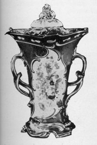 Minton Vase: With cover and handles, the background color of this piece is moss green. The reserves are of finely painted flowers. Made early in the 19th Century, the modeling is in the Louis XV manner. Minton Vase: With cover and handles, the background color of this piece is moss green. The reserves are of finely painted flowers. Made early in the 19th Century, the modeling is in the Louis XV manner.