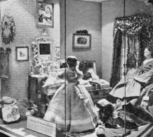 Packing for the Christmas Journey: This setting shows Betsy and Mathilda Greiner just before they have completed their packing. The chest of drawers is a miniature of this period, the rug a restored piece of needlepoint and the dolls from the collection of Miss Sidney Howell. Packing for the Christmas Journey: This setting shows Betsy and Mathilda Greiner just before they have completed their packing. The chest of drawers is a miniature of this period, the rug a restored piece of needlepoint and the dolls from the collection of Miss Sidney Howell.