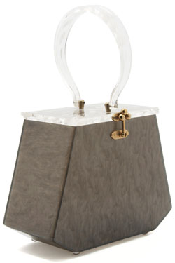 This gray Lucite handbag with a carved floral handle and top is stamped "Florida Handbags." From the estate of Norma Seidman, Lincolnwood, Illinois. A Grey Lucite Handbag, with a carved floral handle and top. Stamped: Florida Handbags. Property from the Estate of Norma Seidman, Lincolnwood, Illinois.