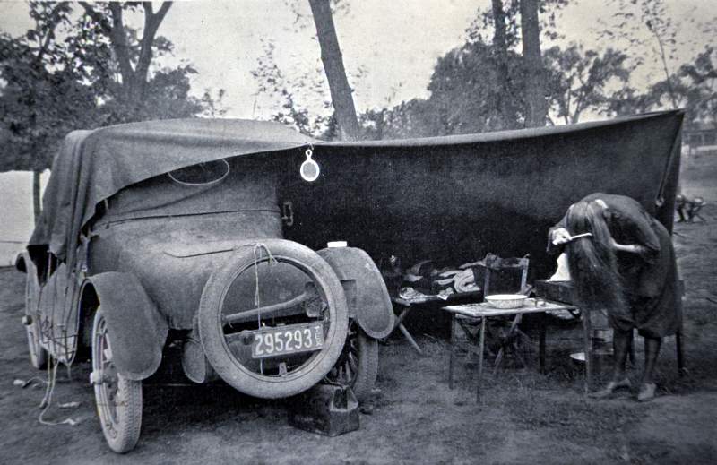 10-F-202 A car camper does a little rustic grooming in Rocky Mountain National Park during the 1920s.