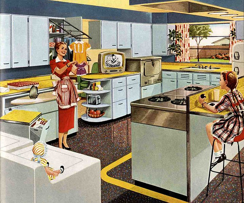 retromania_50skitchen This 1953 advertisement for KitchenMaid cabinets shows a housewife delighting in the modern marvels of her kitchen. Via RetroRenovation.com.