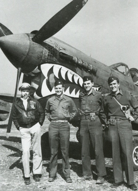 shark mouth Top: Staff Sgt. Cyril Dworak, an air gunner, had a fellow airman in the 96th Bomb Group, Joe Bodner, paint his jacket. The swastika denotes a victory over a German fighter plane. Above: Officers of the 23rd Fighter Group pose with their "Shark Mouth" P-40. From the collection of John Campbell.