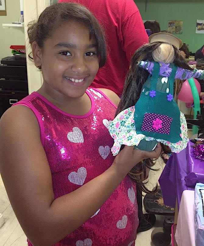 wrap doll A girl poses with the African wrap doll she made at a class at the National Black Doll Museum. From the museum's Facebook page.
