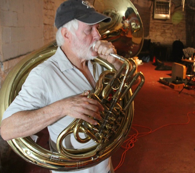 hawleyhelicon Zlatne Uste member Emerson Hawley plays a helicon in a New York practice space. He uses his body to point the horn's bell, which determines how loud it will sound to the crowd. (Via the “Brasslands” Facebook page)