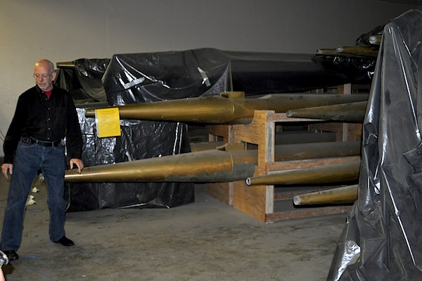 Michael Evje standing at the tapered feet of the organ's display pipes. Air from two 20 horsepower blowers enters all of the organ's 7,500 pipes through these smaller ends.