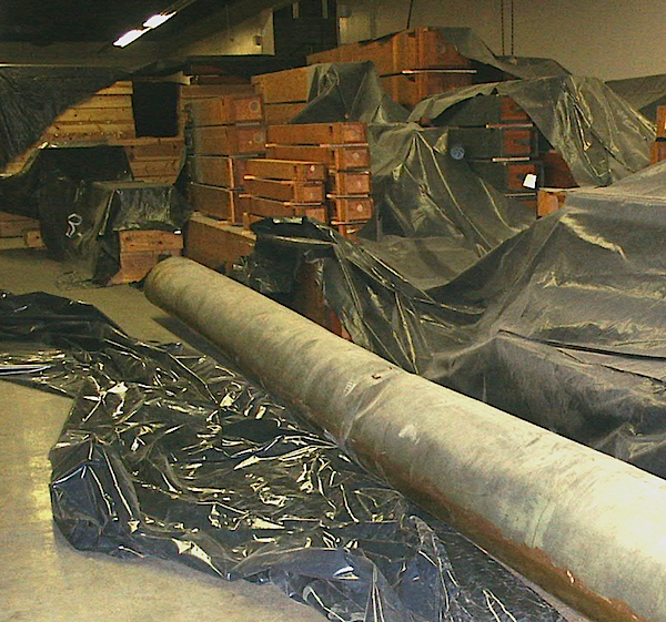 The organ's largest façade pipe is 32 feet long. Its storage on the floor of Brooks Hall has done more damage to it than the earthquake. In the background are many of the organ's wooden pipes.