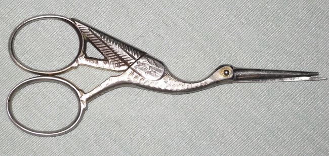 storkscissors Expectant mothers often used stork-shaped objects like these embroidery scissors. Stork-shaped clamps were even used to cut umbilical cords.