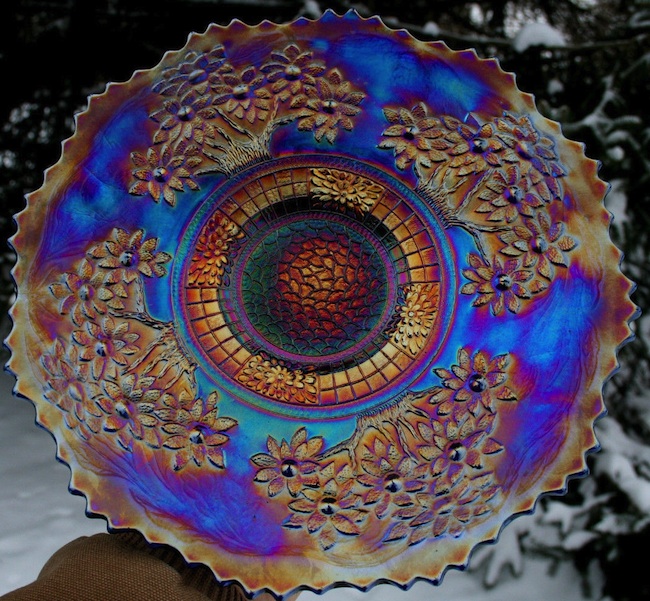 ugly_carnivalglass Carnival glass pieces, like this Fenton Orange Tree plate, were given away as prizes at carnivals and movie theaters in the 1910s and '20s. With orange iridescence on a base of electric blue, this plate qualifies as kitsch.