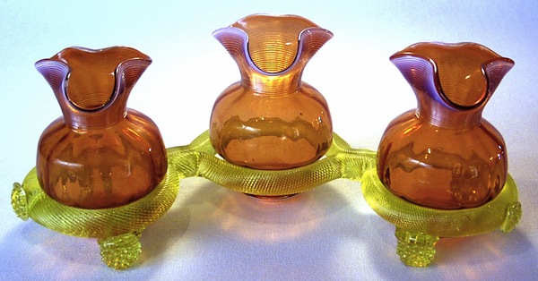 webbdoubleviewSM Above: Flower vases made at the Thomas Webb & Sons factory in England. The vases rest on a Vaseline glass base. Photo via Dave Peterson at <a href="http://www.vaselineglass.org/">VaselineGlass.org</a> Top: The relationship between a piece of glass's propensity to glow and its uranium content is often not predictable. The piece at left contains no uranium at all, while the dark piece at bottom-center contains the most of the group. Photo via <em><a href="http://www.schifferbooks.com/vaseline-glassware-fascinating-fluorescent-beauty-3468.html">Vaseline Glassware</a></em> by Barrie Skelcher.