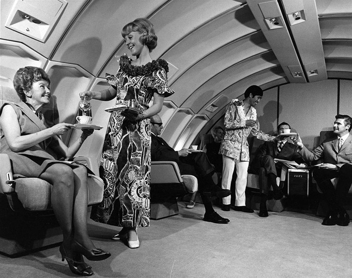 airlines_hawaii_papermag In a 1970s promotional photo for United, flight attendants wear muumuus, aloha shirts, and leis onboard a flight to Hawaii. (Via Museum of Flight)