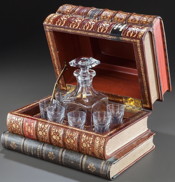 Mantique-edit_A BACCARAT DECANTER SET IN A LEATHER FAUX BOOK-FORM CASE-2 This faux stack of books holds a 20th century French Baccarat decanter. (Via "Mantiques")