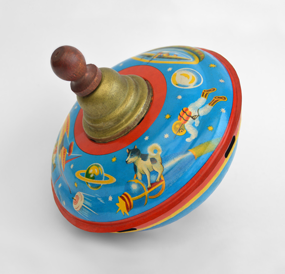 Made by S. I. Toys, this 1958 spinning top depicts Laika standing on a version of Sputnik 2 surrounded by a space-themed frieze. Initially, the lack of images released by the Soviet space program meant it was assumed that Sputnik 2 had the same design as Sputnik 1. (© FUEL Publishing / Marianne Van den Lemmer)