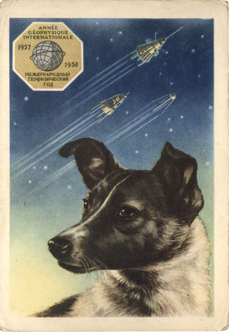 A portrait of Laika by the artist E. Gundobin, with the first three Sputniks in the background. Text of this 1958 postcard from the USSR reads "International Geophysical Year 1957–1958." (© FUEL Publishing)