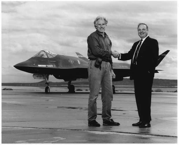 Photographer Bob Seidemann (left) shakes hands with Robert Sandusky, chief designer of the Northrup YF-23 behind them, Edwards Air Force Base, 1991.