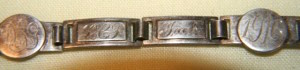 This transitional Machine Age forget-me-not bracelet has round disks that resemble love tokens. (Courtesy of the Love Toke Society)