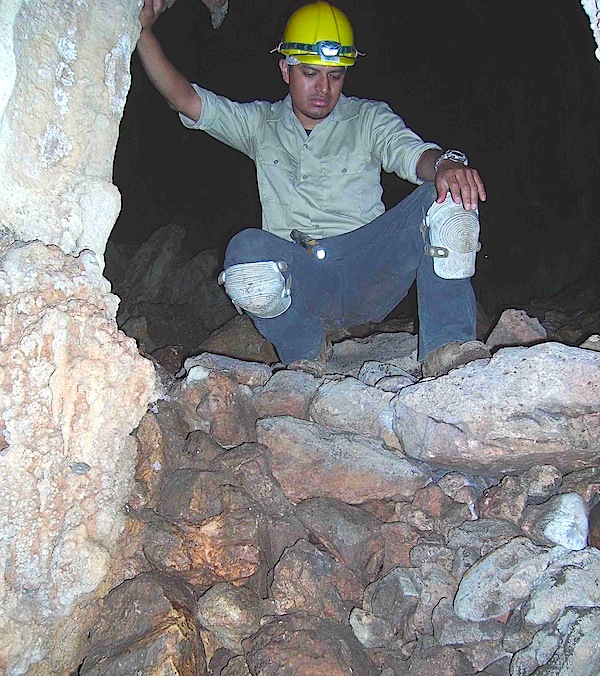 A student from Cal State L.A. crouches on a man-made retaining wall built inside the Midnight Terror Cave. Image via <a href="http://web.calstatela.edu/academic/anthro/MidnightTerror.htm">Cal State L.A.</a>