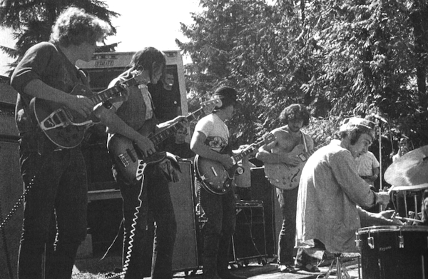 Country Joe and the Fish playing at the Piano Drop. Note the equipment truck parked behind them.