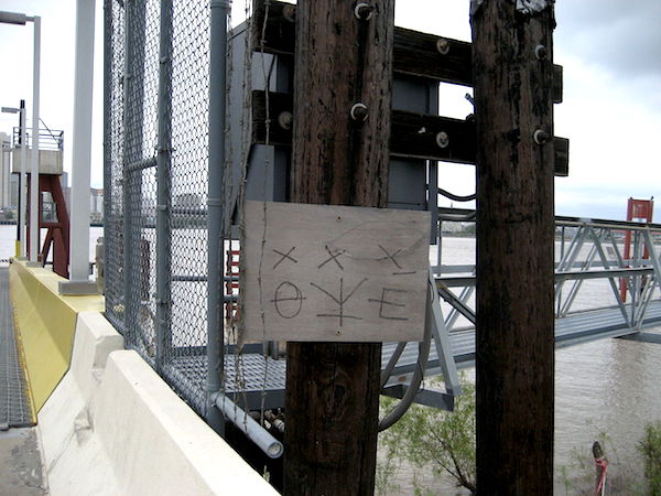 Hobo symbols mark the Algiers entrance to the Canal Street Ferry across the Mississippi River in New Orleans. The ferry is free for pedestrians or people on bicycles, so the symbols indicate it's a "good way to go." (Photo by Infrogmation, via WikiCommons)