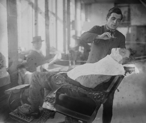 A barber gives a hobo a shave at New York's Hotel de Gink in the 1910s. (From the Bain Collection, Library of Congress)