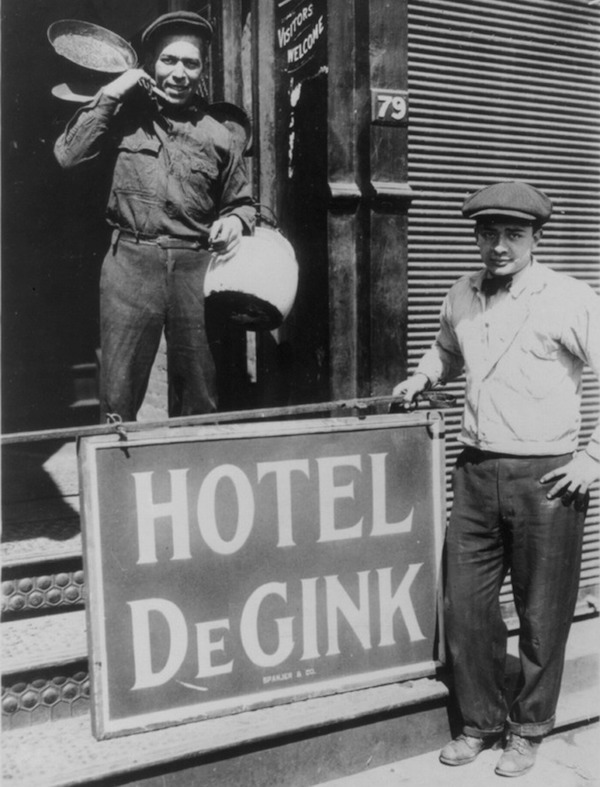 Two men help move a Hotel de Gink, or a hobo shelter run by hoboes, into an old button factory in New York City's Bowery district on April 8, 1915. (From the Bain News Service, Library of Congress)