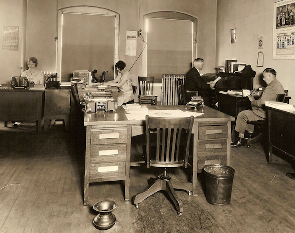 Typical floor companions in offices of the 1920s were waste baskets and spittoons, as seen in this photograph taken in 1929. Photo via Early Office Museum.