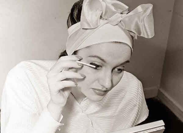 A woman applies makeup at Helena Rubinstein's Fifth Avenue salon. (By Nina Leen/Life Magazine, via Glamour Daze)
