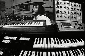 Top: Keith Emerson performing live on his Moog modular synthesizer. Via Keith Emerson's Facebook page. Above: Pete Townshend in his home studio, with an EMS VCS 3 (at right) sitting atop his Lowrey organ. Via Archive.org.