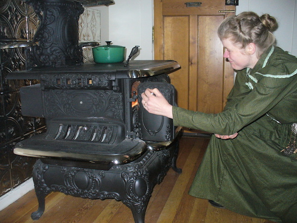 The Chrismans replaced their home's 1980s electric oven with an 1890s cast-iron wood-burning stove, the Charm Crawford Royal. Sarah lights the wood with a long match kept in an antique matchsafe screwed to the wall. (From ThisVictorianLife.com)