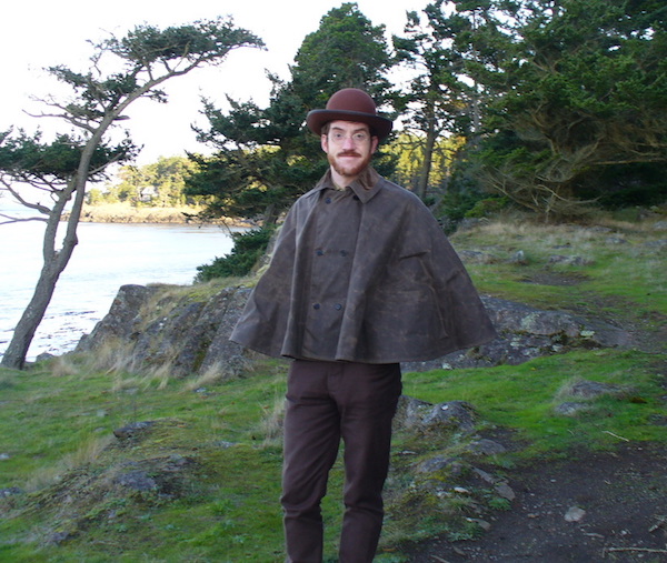Hiking on Lopez Island, Washington, Gabriel wears a waxed canvas cape, sewn by Katharine Andrews after an 1890s original, and bull-denim pants copied from the 1870s originals. (From ThisVictorianLife.com)