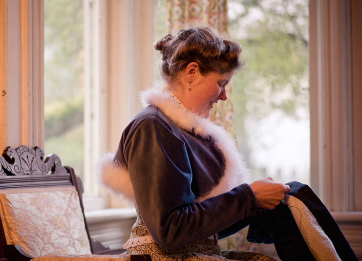 Sarah hand-sews her clothing in an 1880s Eastlake Gothic style chair in her parlor. She wears a cotton velvet bolero jacket with down trim she based on a painting from the period. (Photo courtesy Estar Hyo-Gyung Choi, Mary Studio, via ThisVictorianLife.com)