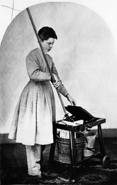 An Oneidan woman named Anna Bolles sports the short hair, plain dress, and pantaloons that were standard in the Community. She's using a mop-wringer invented by Community member John Leonard. (From the Oneida Community Collection at Syracuse University Library in New York)