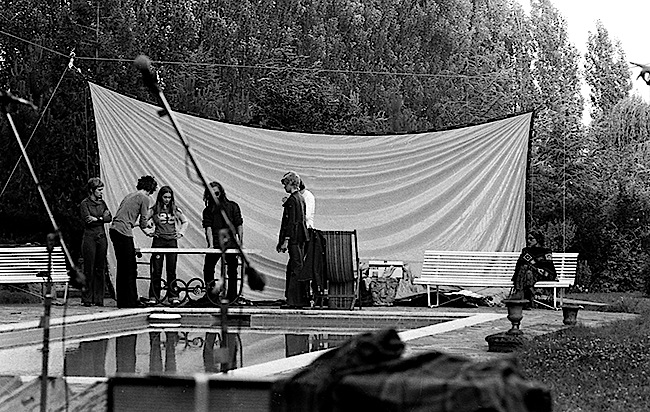 Bill Ham (partially obscured by a microphone stand) and other members of Light Sound Dimension preparing for their poolside performance at Château d'Hérouville in 1971.