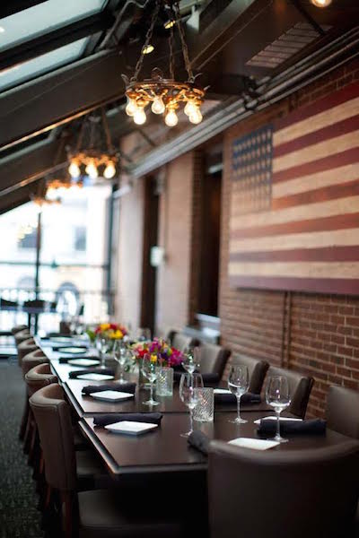 Interesting light fixtures and a folk-art American flag are subtle accents at the elegant Anthem Kitchen and Bar in Boston. (Courtesy of Hospitality Solutions)
