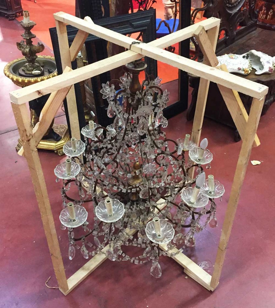 A chandelier displayed in its protective frame at Mercanteinfiera.