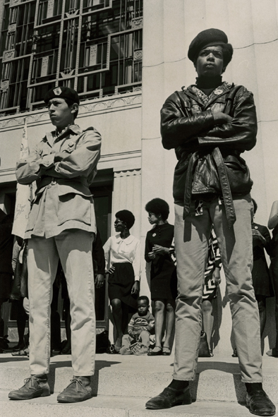 Black Panthers stand in front of the Alameda County Court House on July 14, 1968, the first day of Huey Newton's murder trial. The men in front wear typical Panther-style jackets and berets. In the background, the women sport natural hairdos and slinky Mod skirts. Photo by Lonnie Wilson. (Courtesy of the Oakland Museum of California, the "Oakland Tribune" Collection)