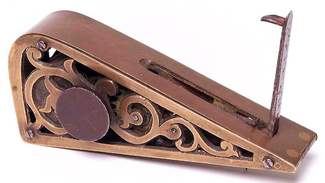 This Clockwork Burglar Alarm from 1880 would be triggers when a door was opened, forcing the lever down and releasing a catch that set off a loud bell.