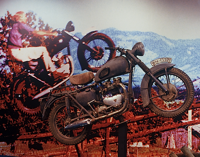 A 2006 exhibition at the Peterson Automotive Museum in Los Angeles featured a blowup of the famous motorcycle jump by Bud Ekins in "The Great Escape," paired with a facsimile of the actual Triumph used in the movie. Ekins sold the original to a stuntman, and its whereabouts remain unknown.